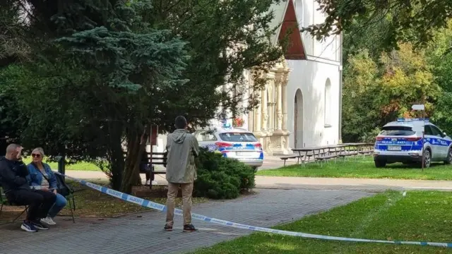 Территория возле религиозного сооружения. В центре и на заднем плане видны полицейские автомобили и пожарно-спасательная техника. Территория огорожена сигнальной лентой