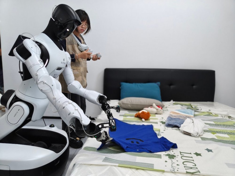 7月30日，浙江清华柔性电子技术研究院具身智能实训场里，00后数据采集员杨慧琴正在训练机器人叠衣服。中青报·中青网记者 宁迪/摄