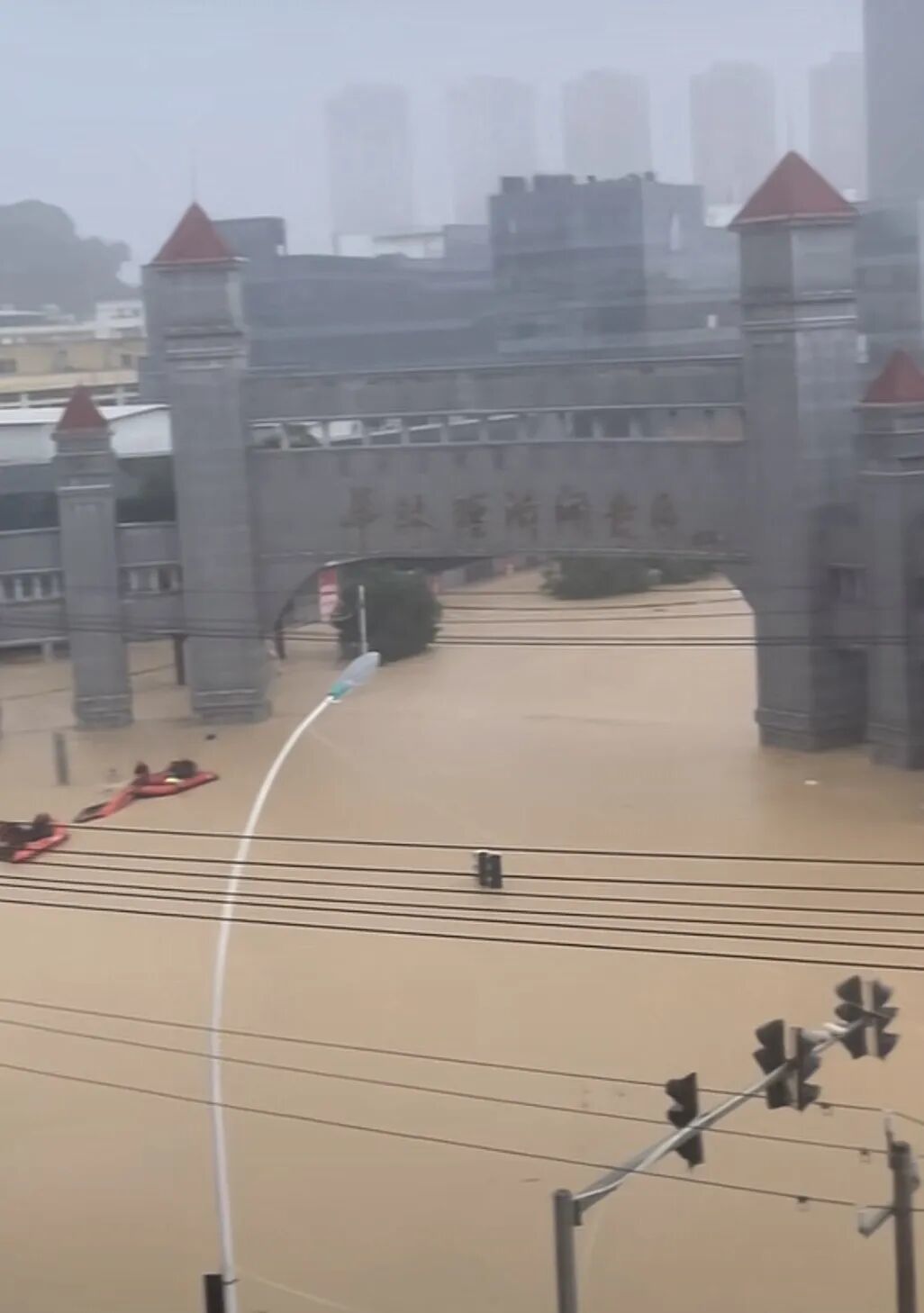 华林经济开发区门口，洪水已漫过园区招牌大半，几艘救援艇正在作业 / 视频截图