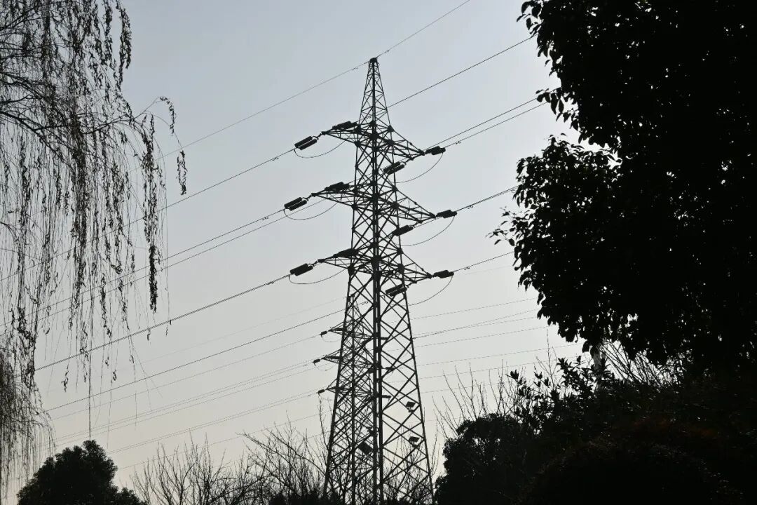 a tall tower with lots of power lines above it