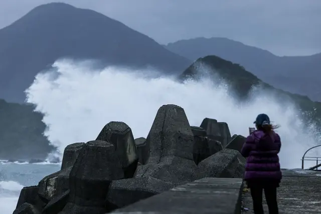 2026年10月22日,基隆一名女子在岸边拍摄海浪,中度台风蔷琵正逼近台湾。