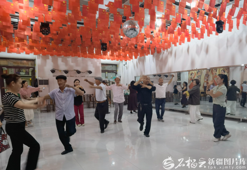 5月21日,在新和县新沙路商业街,石榴花开麦舞队和游客互动。石榴云/新疆日报记者 陈疆林摄