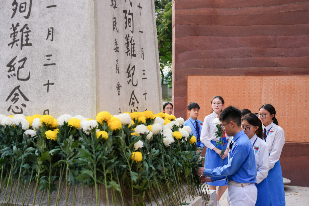 7月5日，在马来西亚首都吉隆坡的南侨机工纪念公园，学生们在南侨机工公祭典礼上献花。新华社记者 陈泽国 摄