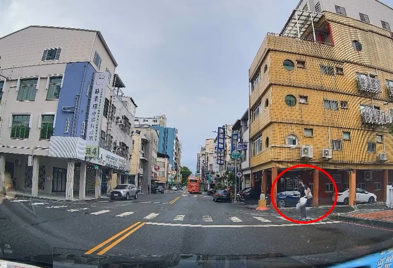 高市一名駕駛昨駕車在忠孝與河南路口，禮讓雙手提袋站路口的男子，但該名男子舉止怪異，後駕駛才駛過路口。圖／截自Threads網友z.x\_lan影片