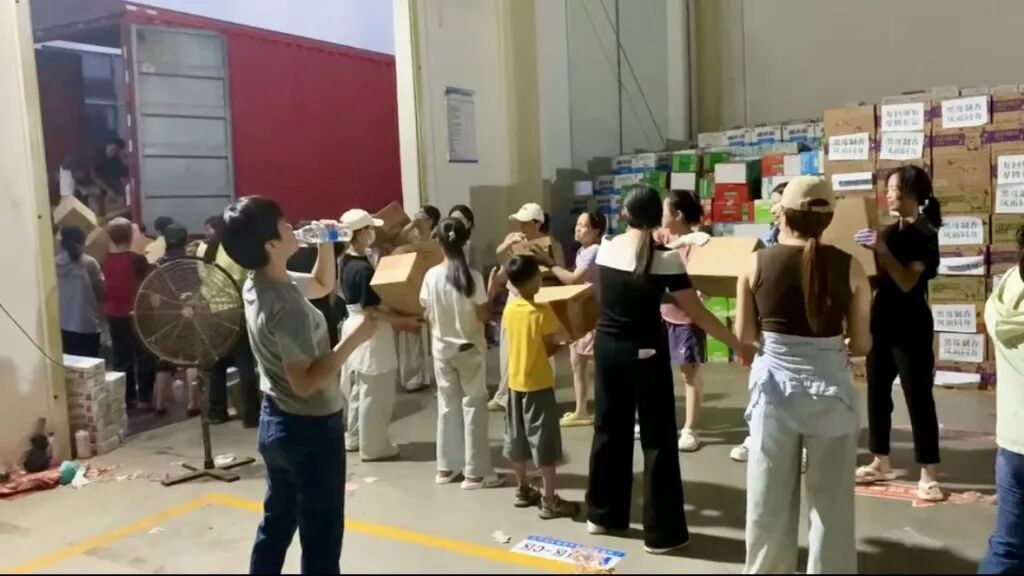 男女老少排成“人链”传递物资