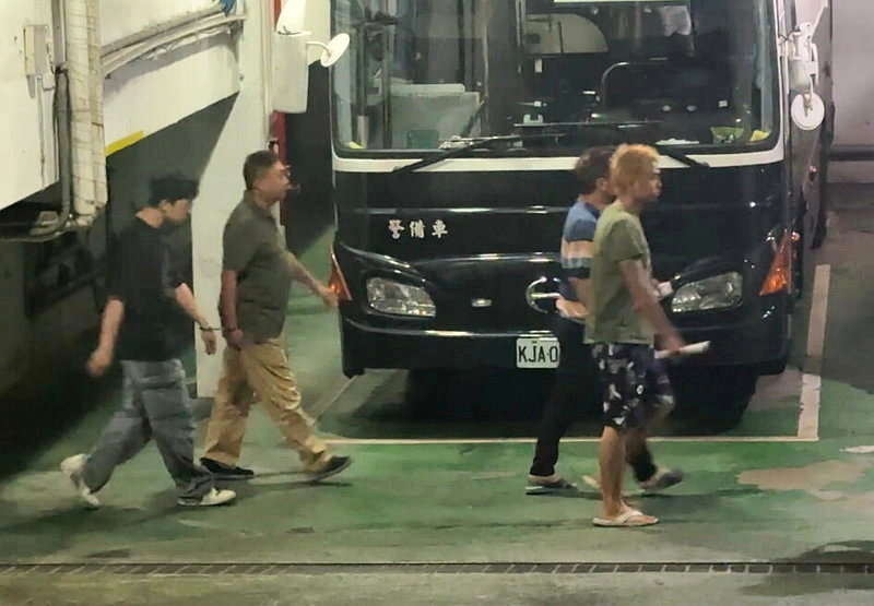 南港分局員警劉政道（左2綠衣者）涉貪遭羈押，凌晨上銬搭囚車前往看守所。記者張宏業／攝影