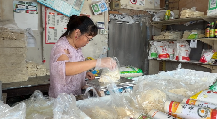 积水退后，上海金山区吕巷镇干巷菜市场，经营户杨阿姨正把米面一摞摞码齐。 “i金山”微信公众号 图