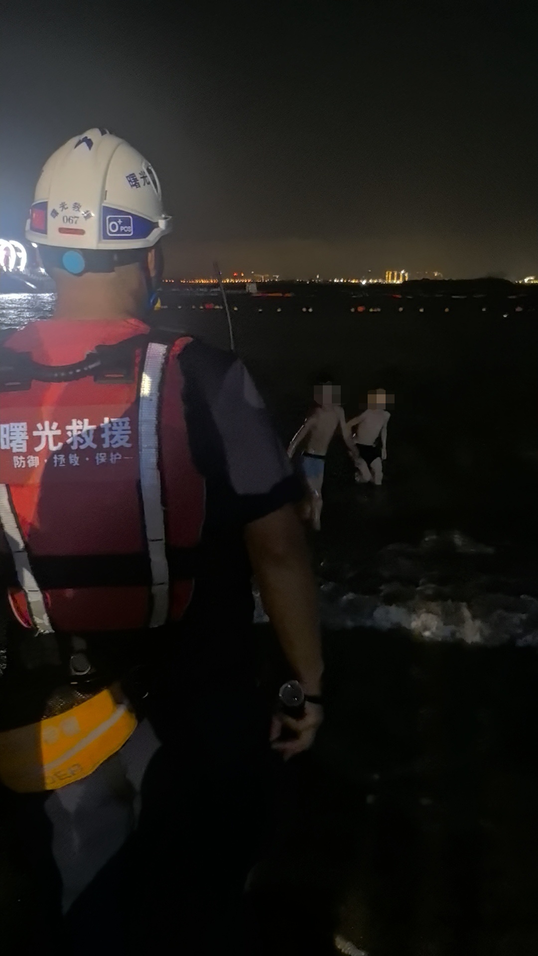 △曙光救援队队员在海边劝阻下水游客。