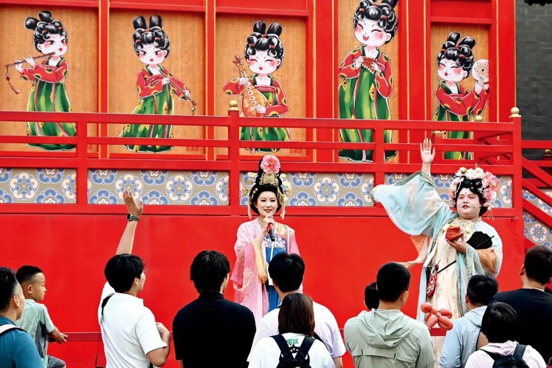 2026年6月9日，唐山河头老街的古装演艺工作人员与现场游客互动。图/视觉中国