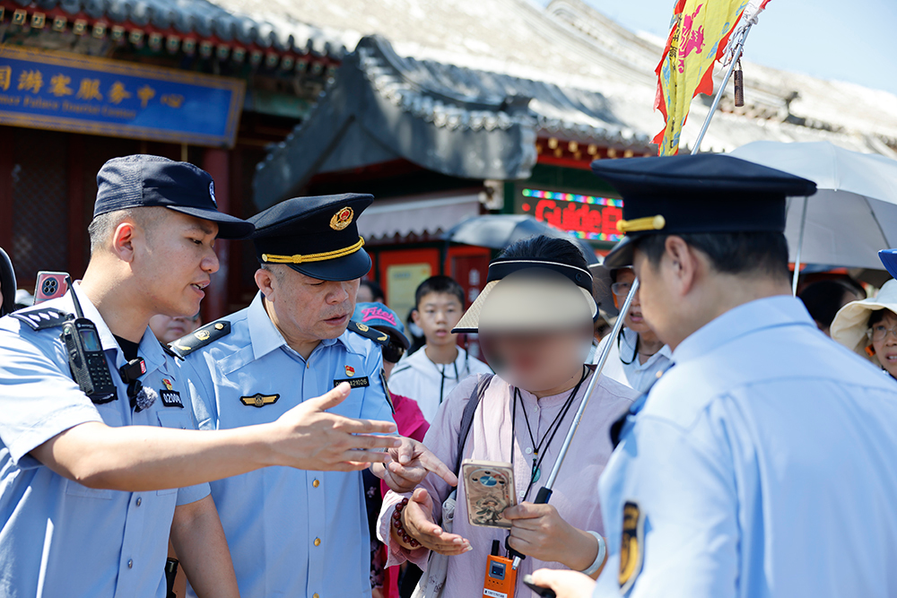 7月15日,民警联合文化市场综合执法队伍在颐和园对导游进行检查 央视网记者 谢博韬 摄