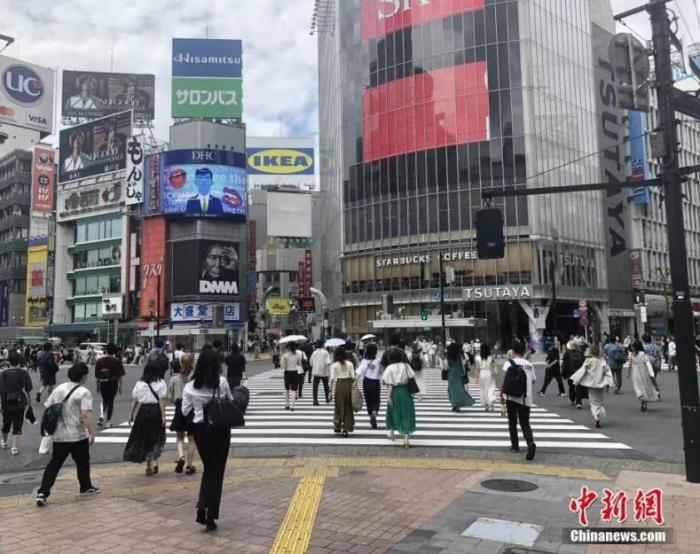 资料图:日本民众穿过涩谷车站前的交叉路口。中新社记者 吕少威 摄