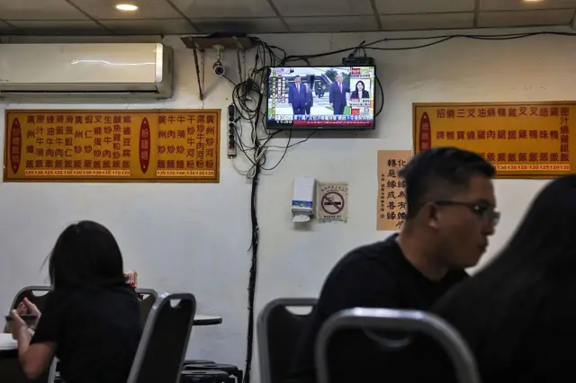 2026年9月25日,台北一家餐厅的顾客正在用餐,电视上播放美国总统特朗普与中国国家主席习近平会晤的新闻。