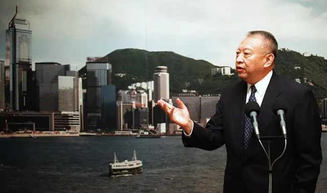 背靠香港海景，董建华对着麦克风讲话