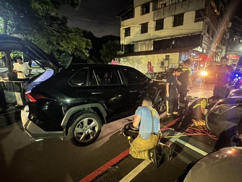 基隆市歐姓男子開車，撞上有喝酒的李姓男子。李男受困底盤下方，消防員頂起休旅車後，救出李男送醫，事故原因由警方調查中。圖／讀者提供
