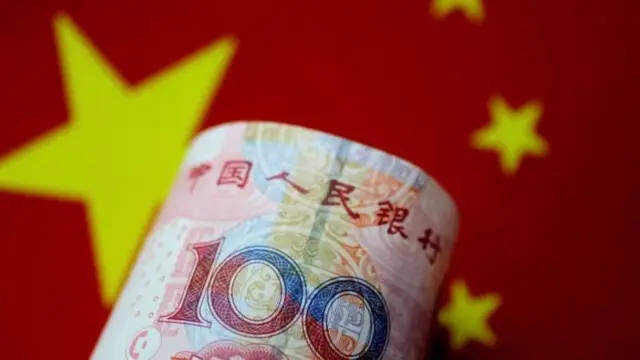 一张人民币，背景是中国国旗