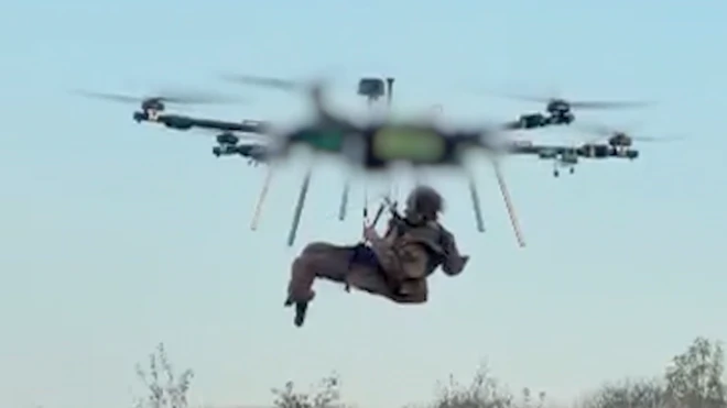 Скриншот из видео, на котором большой воздушный дрон несет человека
