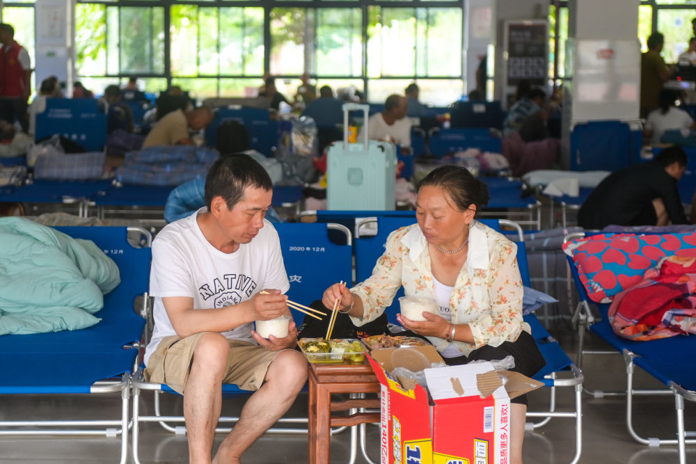 8月9日，群众在浙江温州龙湾区永兴街道罗峰实验学校避灾点吃午饭。新华社记者 江汉 摄