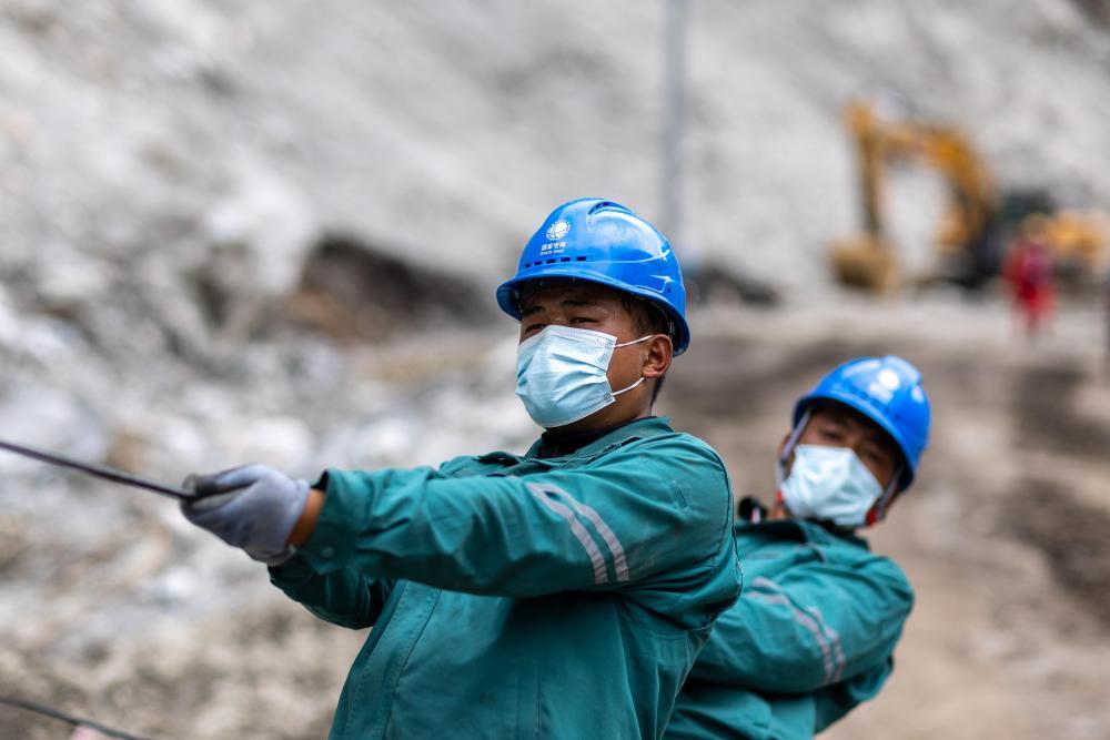 9月3日,在吉隆泥石流灾害核心区,电力工人在放导线。 新华社记者 姜帆 摄