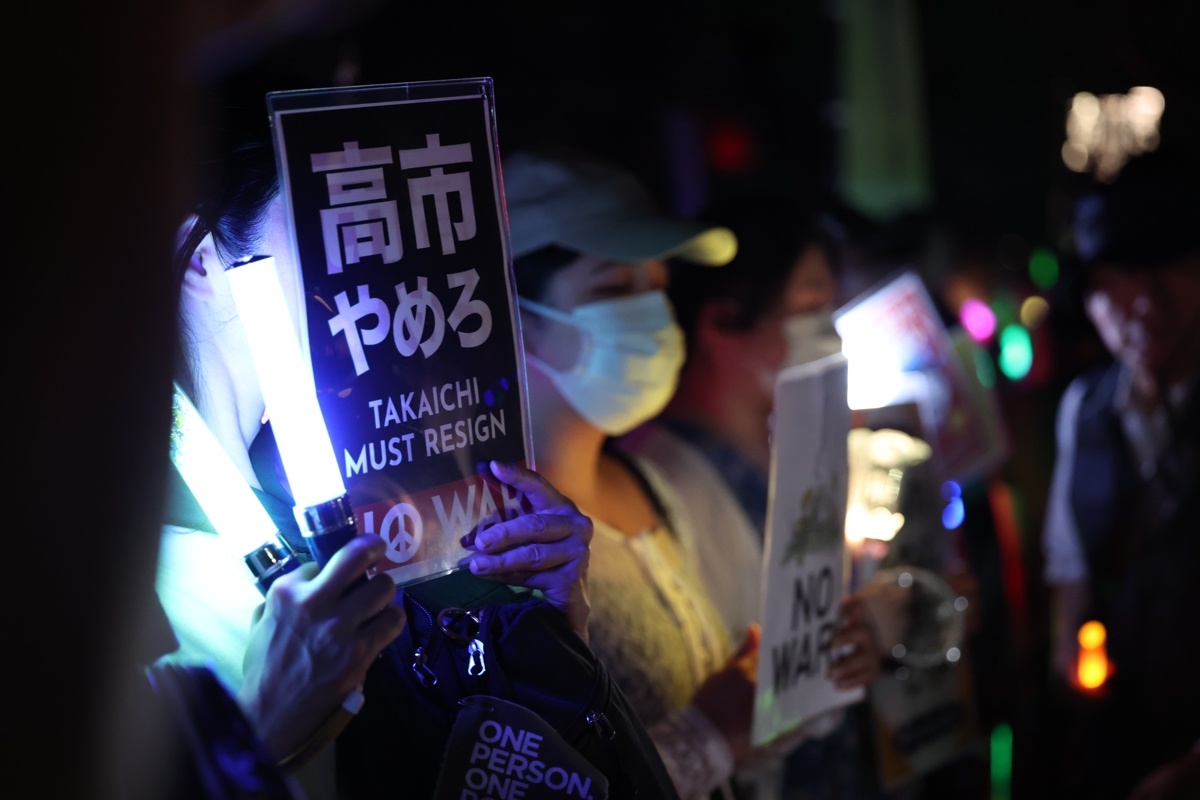 7月10日民众手持标语参加抗议集会 图源:新华社