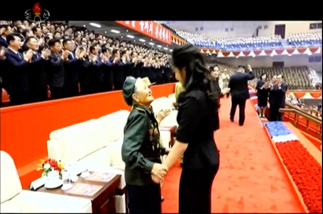 7月27日,金正恩携妻女出席祖国解放战争胜利73周年纪念演出。演出前,金正恩的女儿和老兵代表握手、拥抱致意。图/朝鲜中央电视台报道截图。