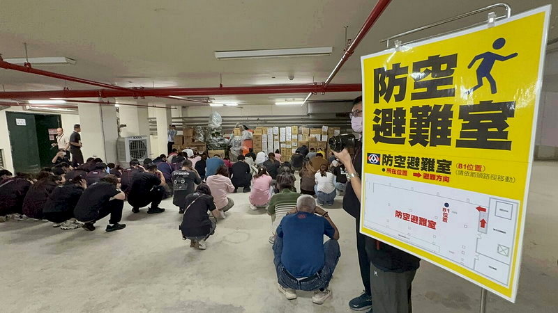 高雄市今天上午10時舉行2026城鎮韌性防空演習，全聯員工在地下室就近靠牆角蹲下抱頭避難。記者石秀華／攝影