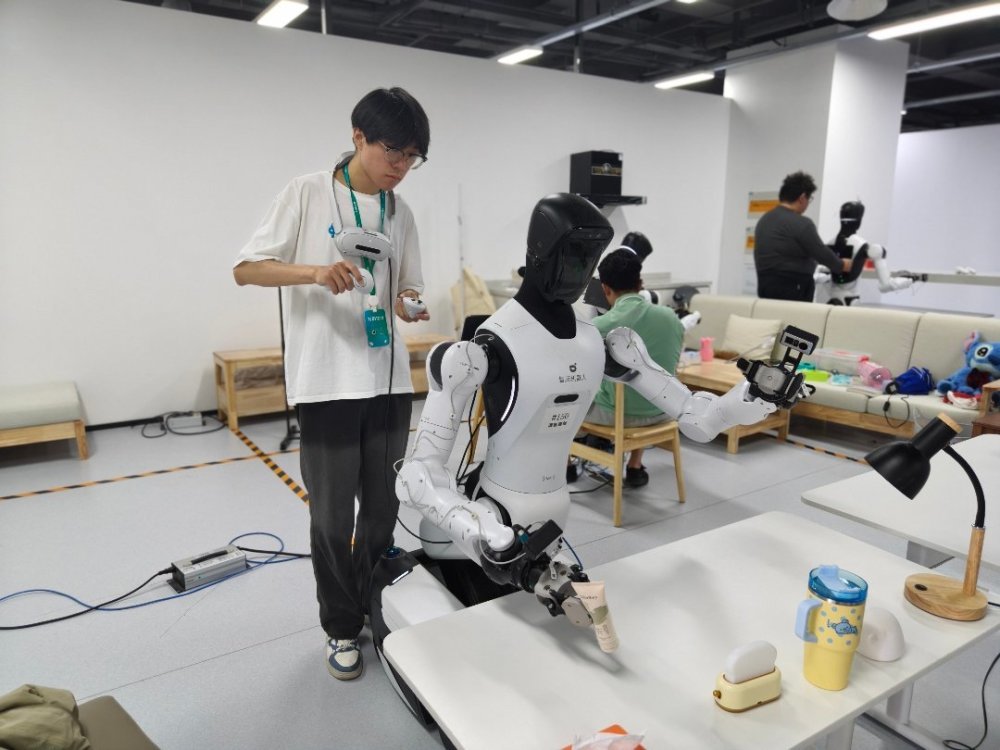 7月30日，浙江清华柔性电子技术研究院具身智能实训场里，一名00后数据采集员正在训练机器人拿取桌上的各种物件。中青报·中青网记者 宁迪/摄