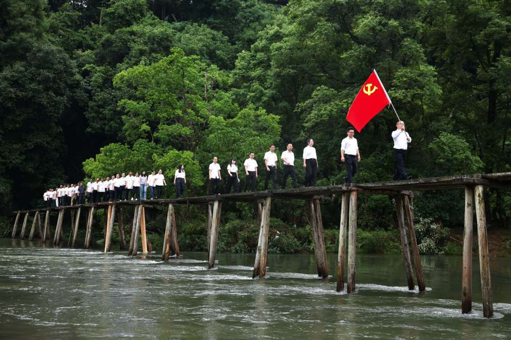 2026年7月1日，贵州省黔东南苗族侗族自治州黎平县高屯街道参加“重走长征路”活动的干部职工从修整后的红军桥上经过。新华社记者 杨文斌 摄
