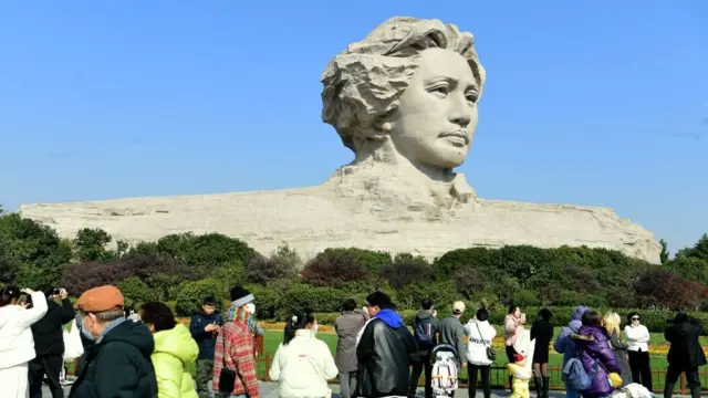 游客经过长沙橘子洲头的青年毛泽东雕像