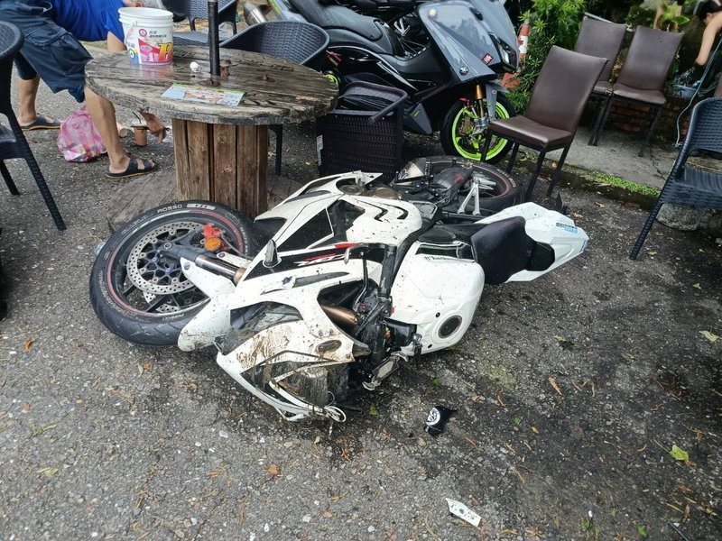 21歲林姓騎士疑壓到前起事故清理漏油後鋪設的木屑油漬打滑，衝進財貿灣咖啡廳座位區，造成1名女顧客受傷。記者張策／翻攝