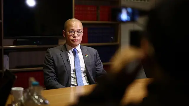 2026年2月9日,黎崇恩受访,盯着镜头。