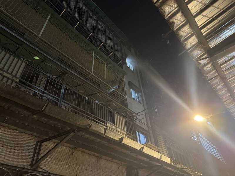 新北市中和區新生街1處舊公寓今晚10時許陽台冒出火煙,1名疑似起火戶男子在樓門口,涉嫌持刀企圖阻擋消防人員上樓,當場遭壓制交由警方帶返所。記者王長鼎/翻攝