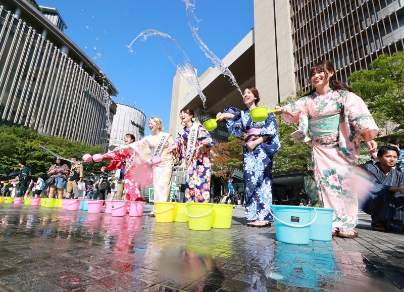 身穿浴衣的日本民眾2023年7月22日在JR大阪站附近的梅北廣場進行「打ち水」灑水降溫活動。路透/讀賣新聞