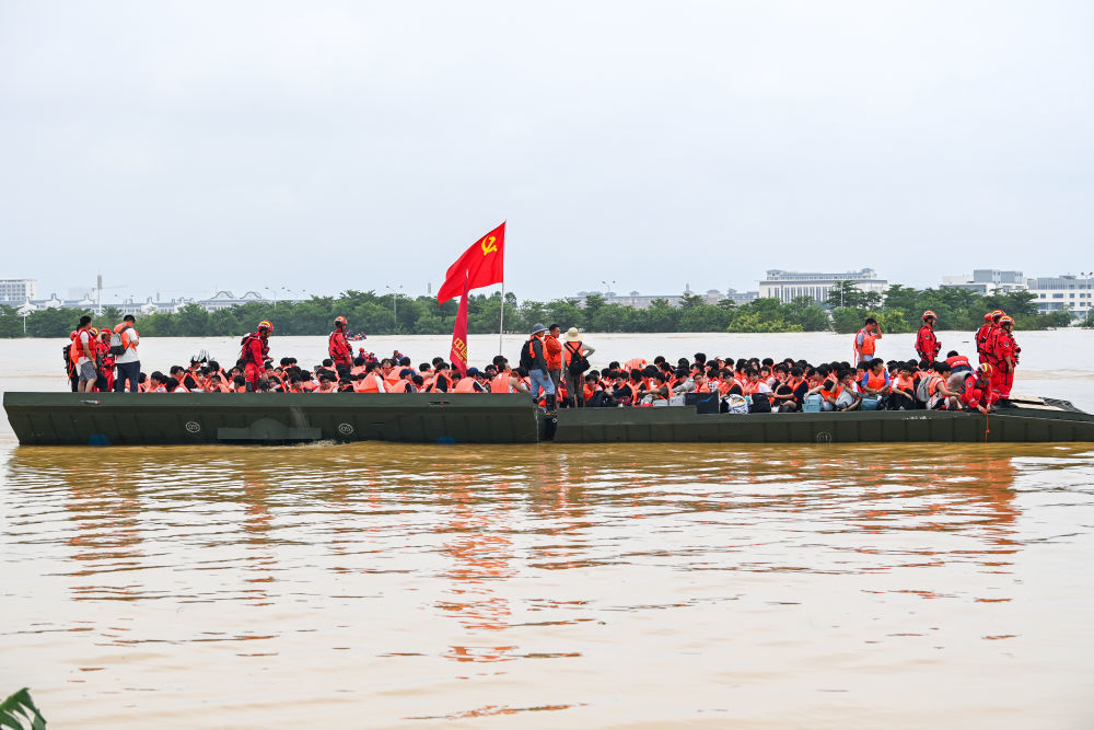 ↑7月9日,在广西贵港市西江教育园区,救援人员使用动力舟桥转运被困学生(无人机照片)。新华社记者 曹祎铭 摄