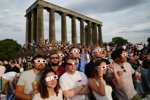 爱丁堡卡尔顿山(Calton Hill)聚集大批民众观赏日食,但他们不得不与多云天气周旋,等待云层散开的一刻。
