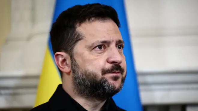 Зеленский на фоне украинского флага.
