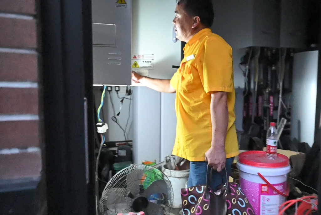 张建军检修余先生家电路情况。 澎湃新闻记者 张呈君 图