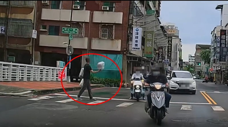 高市一名駕駛昨駕車在忠孝與河南路口，禮讓雙手提袋站路口的男子，但該名男子舉止怪異，後駕駛駛過路口，男子後來又穿梭車陣。圖／截自Threads網友z.x\_lan影片