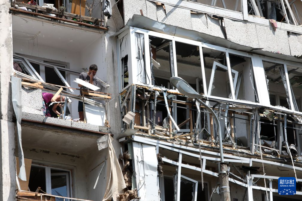 7月2日，在乌克兰基辅市佩切尔斯基区，居民拆除空袭中受损的窗户。新华社发（彼得·德鲁克摄）