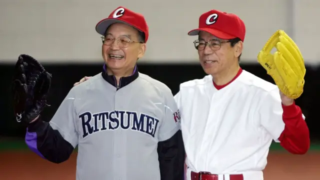 福田康夫（右）与温家宝（左）在北京钓鱼台国宾馆内身穿棒球球衣让媒体记者合照（29/12/2007）