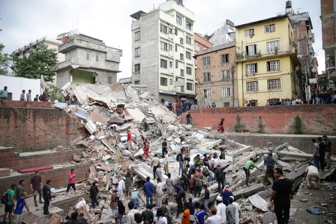 2015年4月,地震过后,加德满都居民在建筑废墟中寻找幸存者。(图源:美联社)