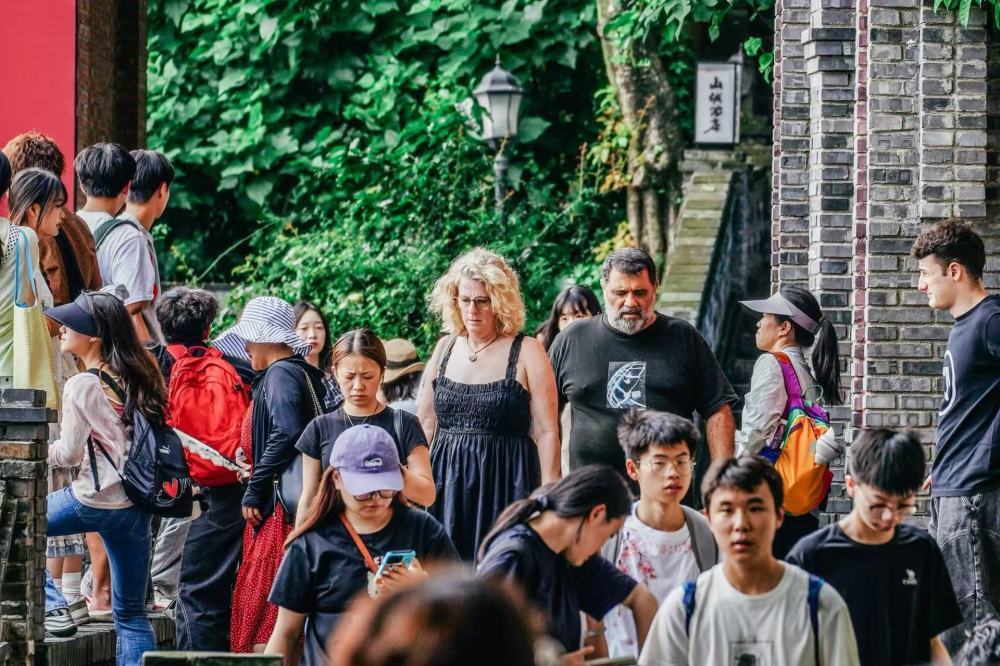 2026年7月，外籍游客在长江边的重庆市南岸区龙门浩老街游览。新华社发