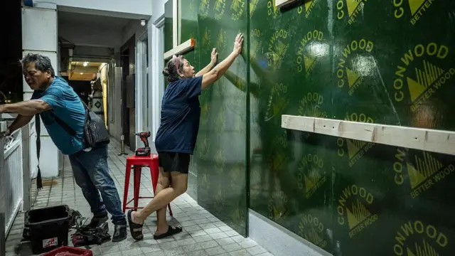 在预测中的超强台风巴威来袭前,关岛一家餐厅的员工正以木板封住餐厅门窗(4/7/2026)