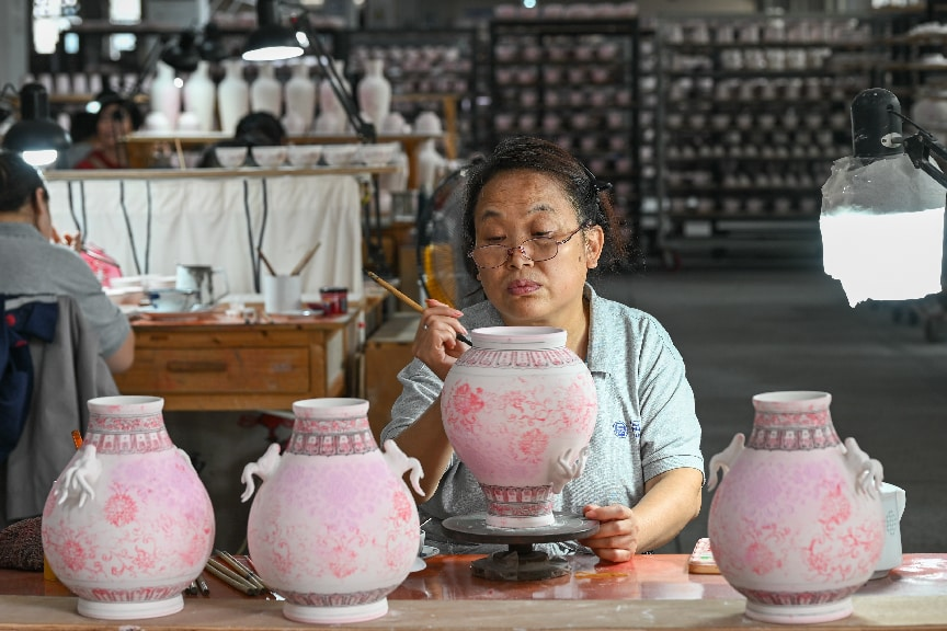 2026年7月7日，江西景德镇，工匠在进行手绘工序，在坯体上绘制各种花面图案。 中新社发 王宇轩 摄