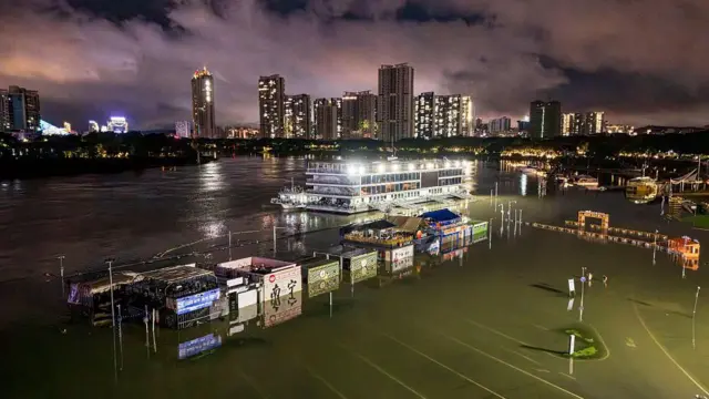 广西南部南宁市邕江码头附近，可见一条沿河步道及商店遭洪水淹没。（6/7/2026）
