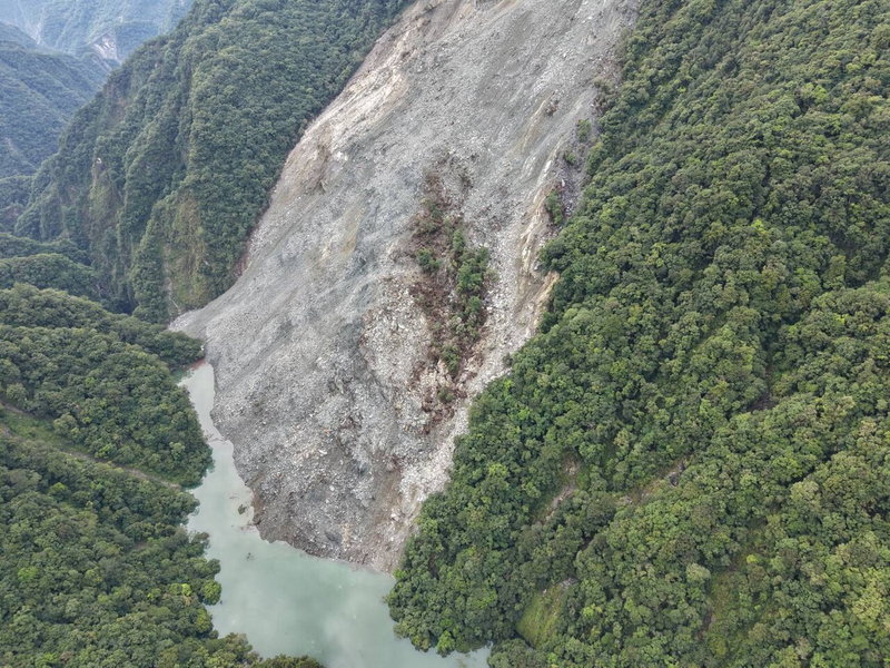 萬里溪堰塞湖持續穩定溢流,不過壩頂右側崩塌土石仍持續沿邊坡緩慢滑動並堆積於河床,林保署花蓮分署將持續追蹤監測。圖/林保署花蓮分署提供