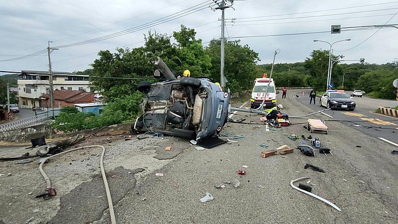 肇事車輛撞斷燈桿卡在外側護欄邊，車身嚴重變形，車輛零件碎片散落一地。圖／民眾提供