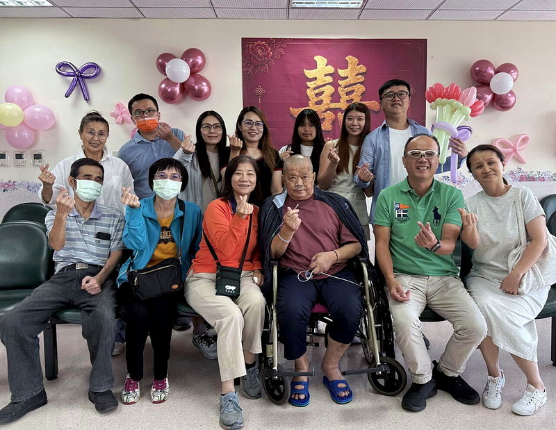 賴姓退休警（前排右三）在家人圍繞下，見證小女兒交換戒指、許下承諾圓夢。圖／烏日林新醫院提供