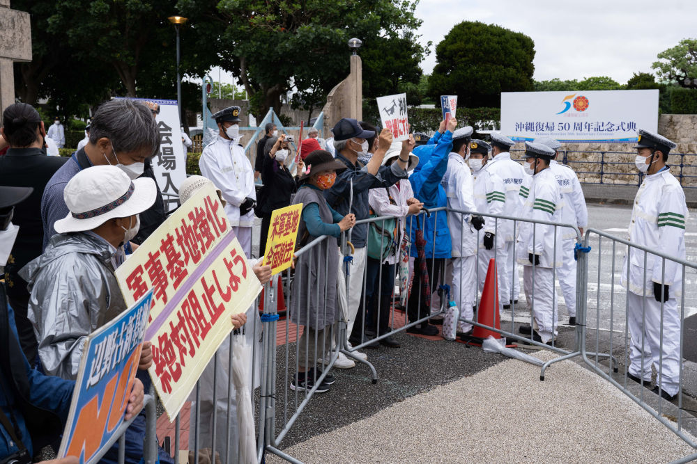 2022年5月15日，在日本冲绳，人们在冲绳回归日本本土50周年纪念仪式现场外抗议，要求削减冲绳美军基地规模甚至将美军基地全部撤出。新华社记者张笑宇摄