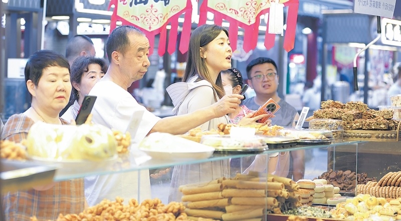 7月5日，市民和游客在昌吉小吃街夜市品美食赏夜景。 梁宏涛摄