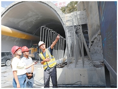中吉乌铁路乌鲁姆巴什1号隧道出口，工作人员正在向中吉记者介绍隧道施工情况。　　本报记者 赵益普摄
